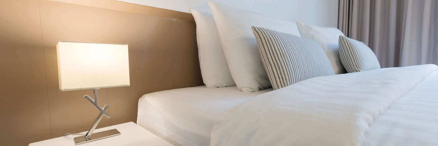 תקריב של מיטה זוגית בחדר מלון